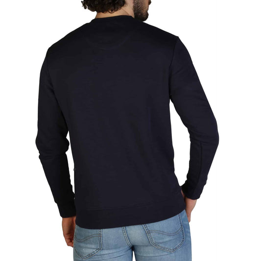 Black Aquascutum sweatshirt with brand logo displayed on the chest, showcased on a male model with a beard and curly hair. Sofybrands Fashion Outlet